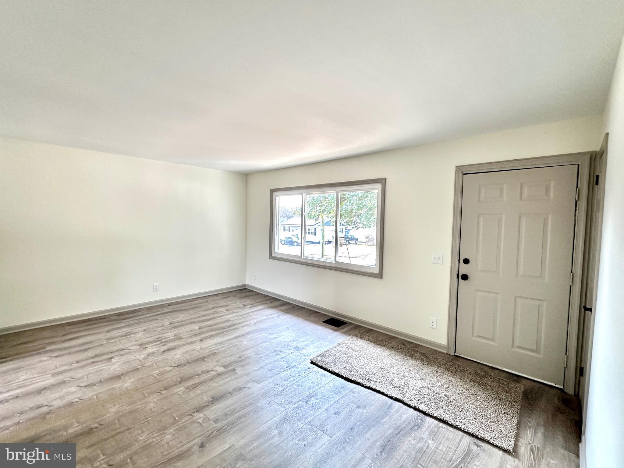 45 Smith Avenue Aberdeen, MD 21001 - Photo 4 of 9 an empty room with wooden floor cabinet and windows