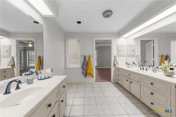 a spacious bathroom with a double vanity sink and a mirror
