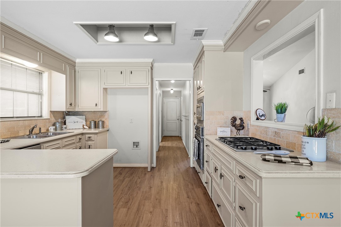 3601 Willow Bend Circle Waco, TX 76708 - Photo 10 of 37 a kitchen with stainless steel appliances a white cabinets stove and wooden floors