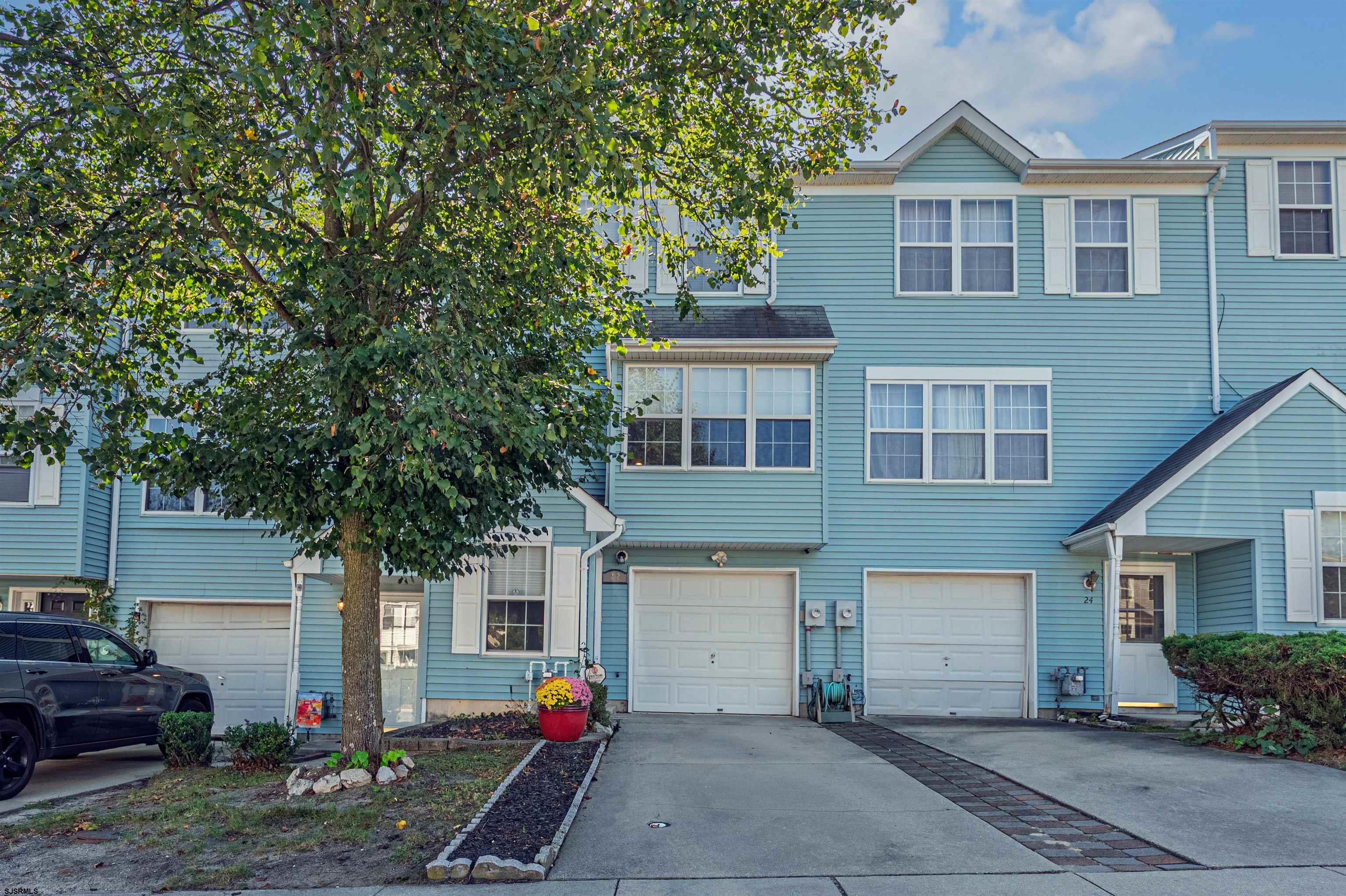 a front view of house with yard and trees around