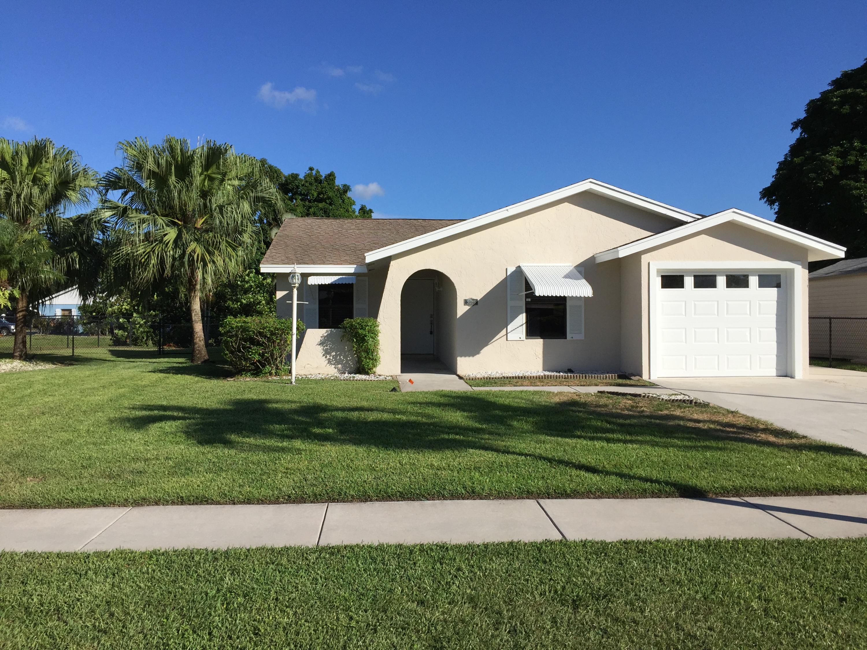 5266 Steven Road Boynton Beach, FL 33472 - Photo 1 of 26 a front view of a house with a garden