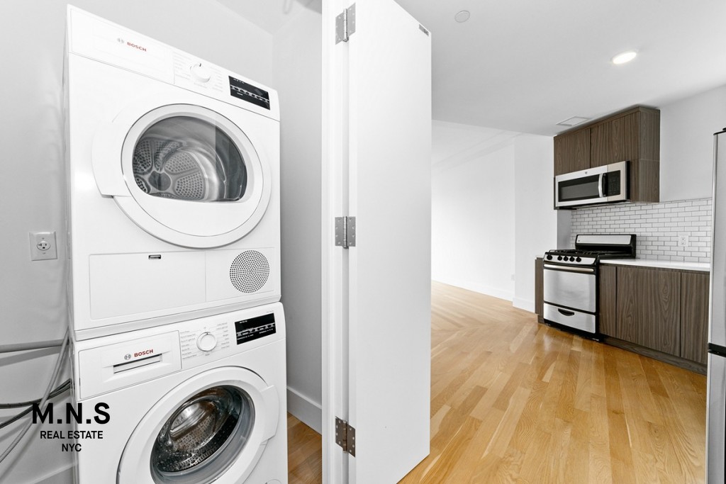 37-14 36th Street, Unit 7Q Queens, NY 11101 - Photo 4 of 20 a view of kitchen and washer and dryer