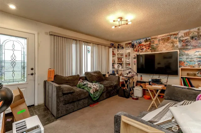 a living room with furniture a flat screen tv and a window