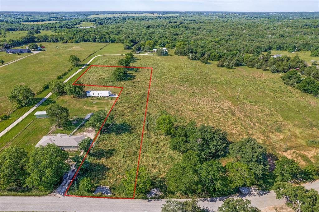 an aerial view of a houses with a yard and lake view