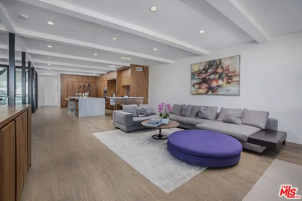 a living room with furniture a rug and kitchen view