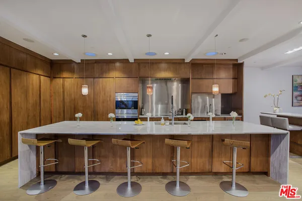 a kitchen with a table chairs sink and cabinets