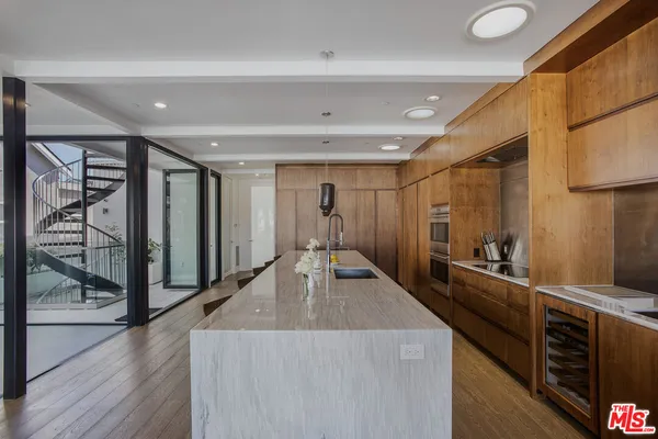 a kitchen with stainless steel appliances kitchen island granite countertop a table and chairs in it