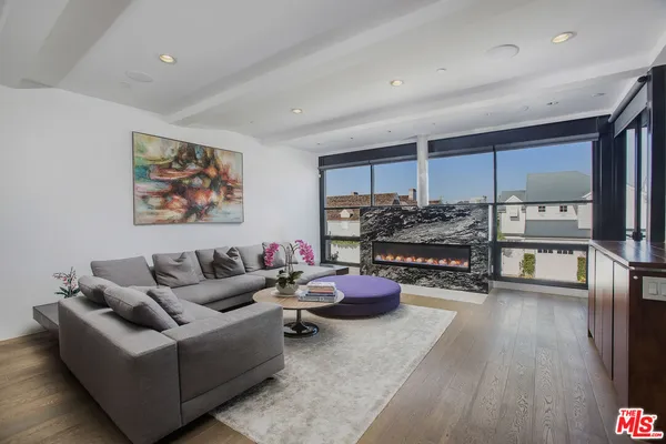 a living room with furniture and a floor to ceiling window