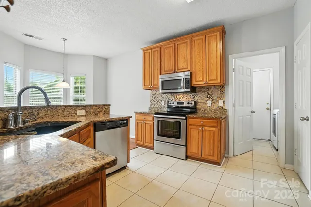 a kitchen with granite countertop a stove sink and cabinets
