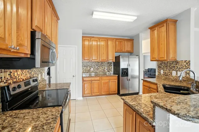 a kitchen with stainless steel appliances granite countertop a stove a refrigerator and a oven