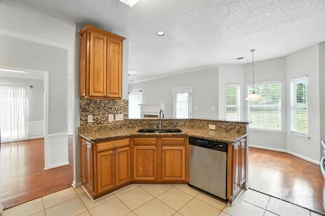 a kitchen with granite countertop a sink and cabinets