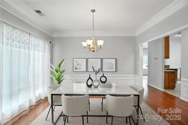 a dining room with furniture a chandelier and wooden floor