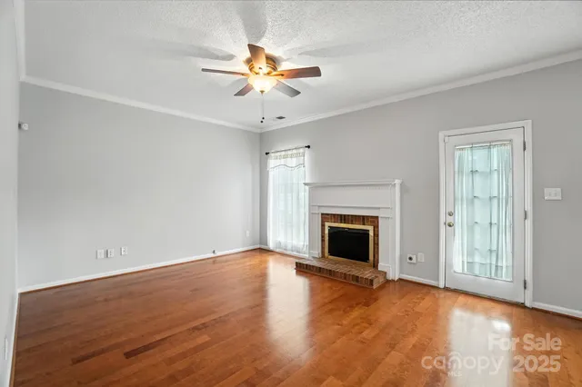 an empty room with windows and fireplace