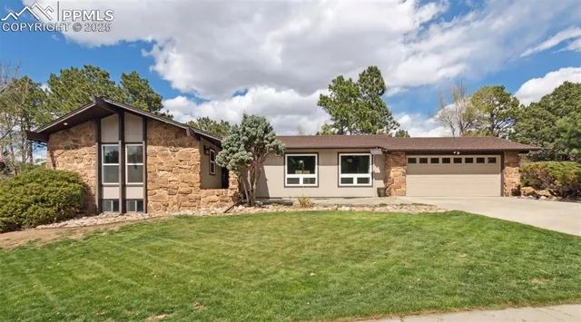 a front view of a house with a garden and yard