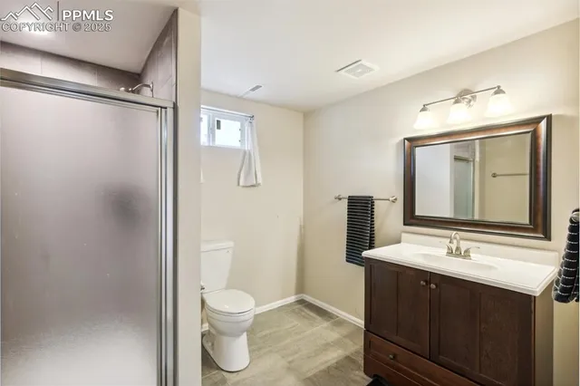 a bathroom with a toilet a sink a mirror and a shower