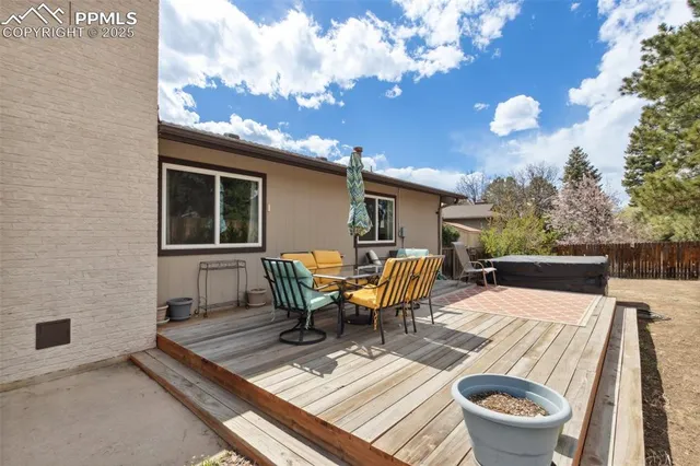 a view of a patio with table and chairs with wooden floor and fence