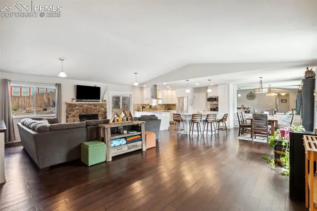 a living room with furniture a flat screen tv and kitchen view