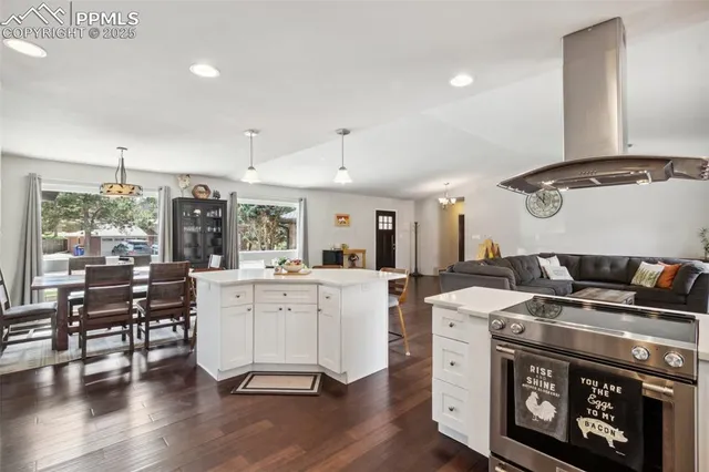a kitchen with a stove and wooden floor