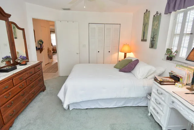 a bedroom with a bed and a flat tv screen on dresser