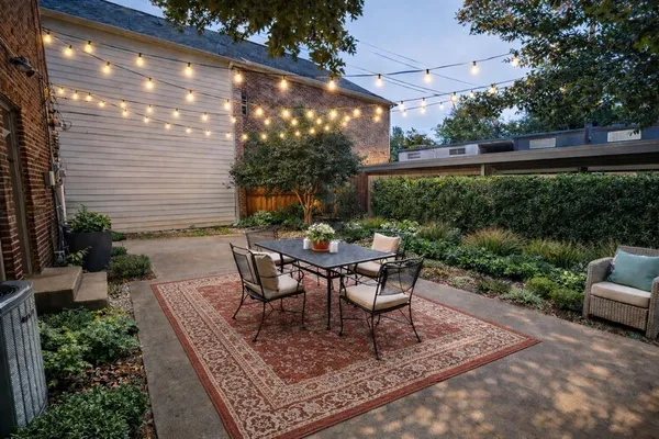 a view of a table and chairs in back yard of a house