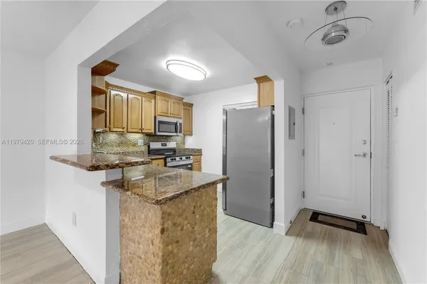 a kitchen with granite countertop a refrigerator and a sink