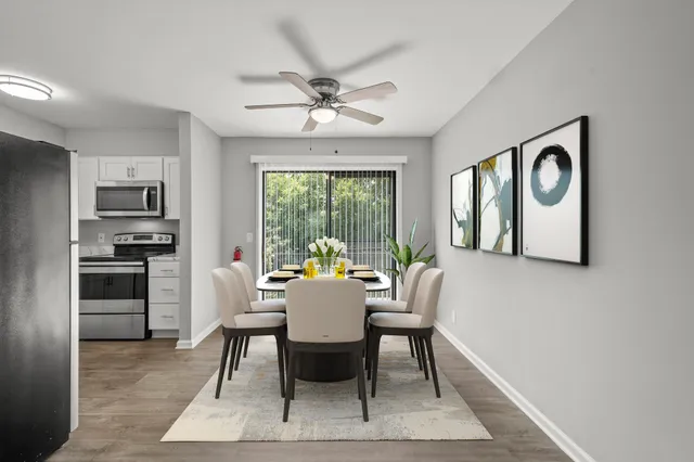a dining room with furniture a chandelier and wooden floor