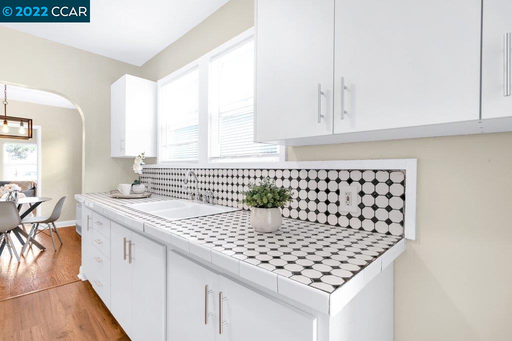 Undisclosed Address Richmond, CA 94801 - Photo 12 of 34 a kitchen with a sink a stove and white cabinets