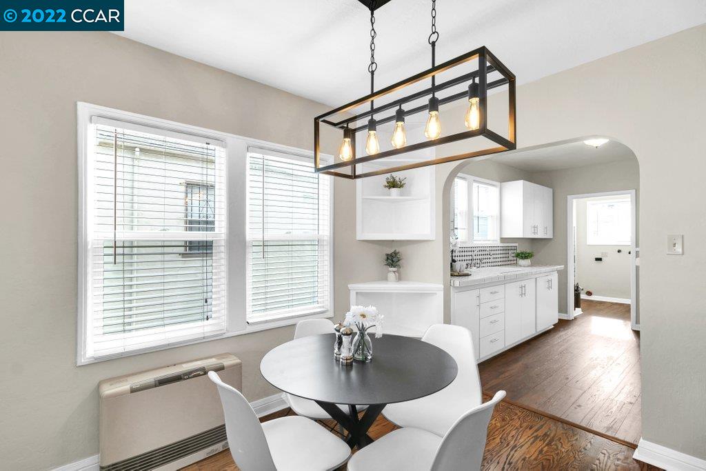 Undisclosed Address Richmond, CA 94801 - Photo 6 of 34 a kitchen with stainless steel appliances kitchen island granite countertop a dining table chairs and a white refrigerator
