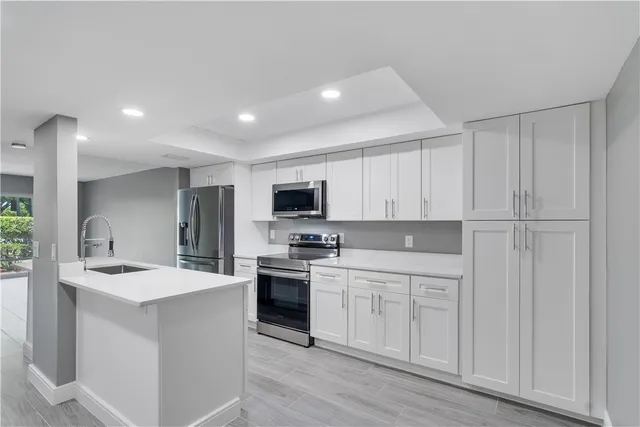 a kitchen with white cabinets sink and stainless steel appliances