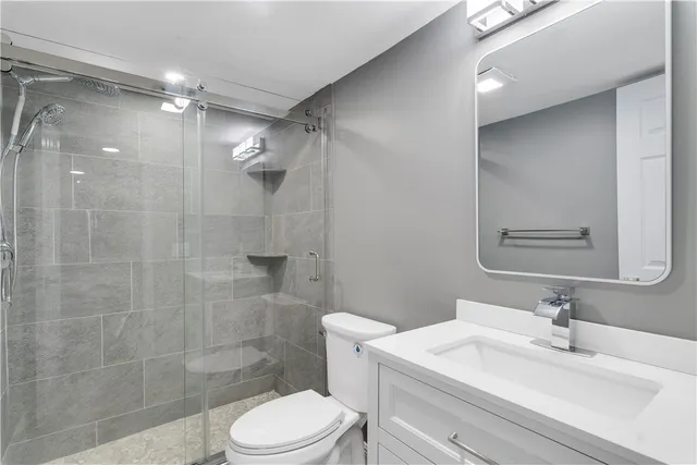 a bathroom with a sink a toilet and shower