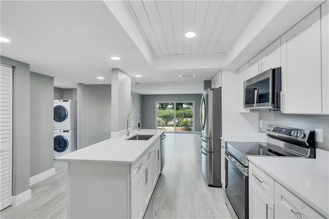 a kitchen with a sink a stove and cabinets