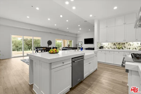 a kitchen with white cabinets and white appliances