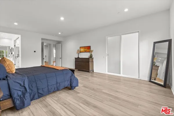 a spacious bedroom with a bed and a flat screen tv