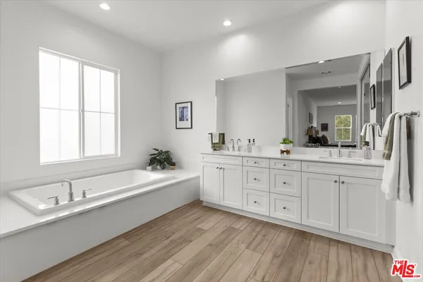 a large bathroom with a double vanity sink a mirror and a bathtub