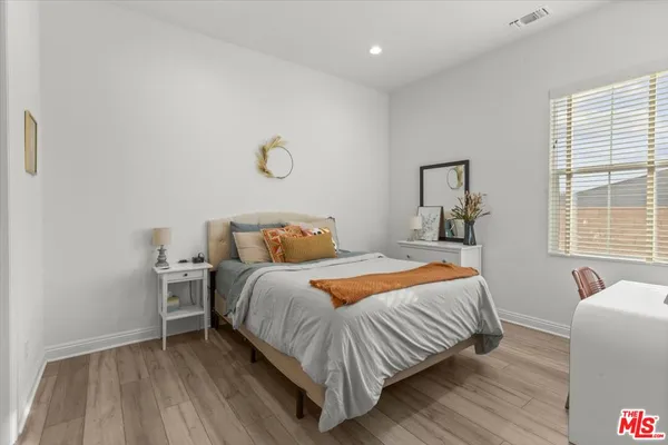 a bedroom with a bed and wooden floor