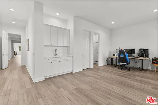 a view of a kitchen with furniture and wooden floor