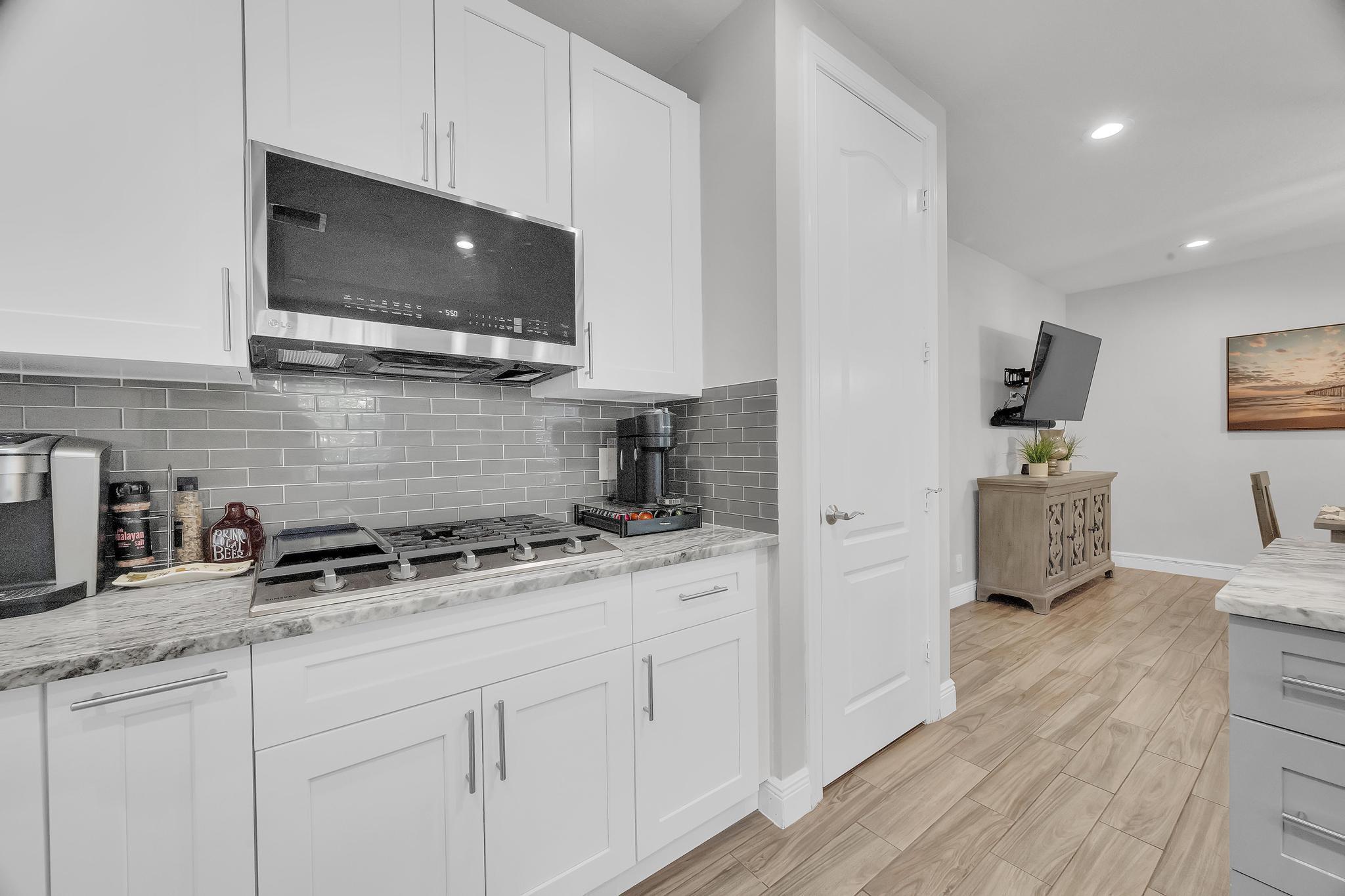 5600 Northeast Trieste Terrace Boca Raton, FL 33487 - Photo 22 of 44 a kitchen with stainless steel appliances granite countertop a sink a stove a microwave a refrigerator and cabinets