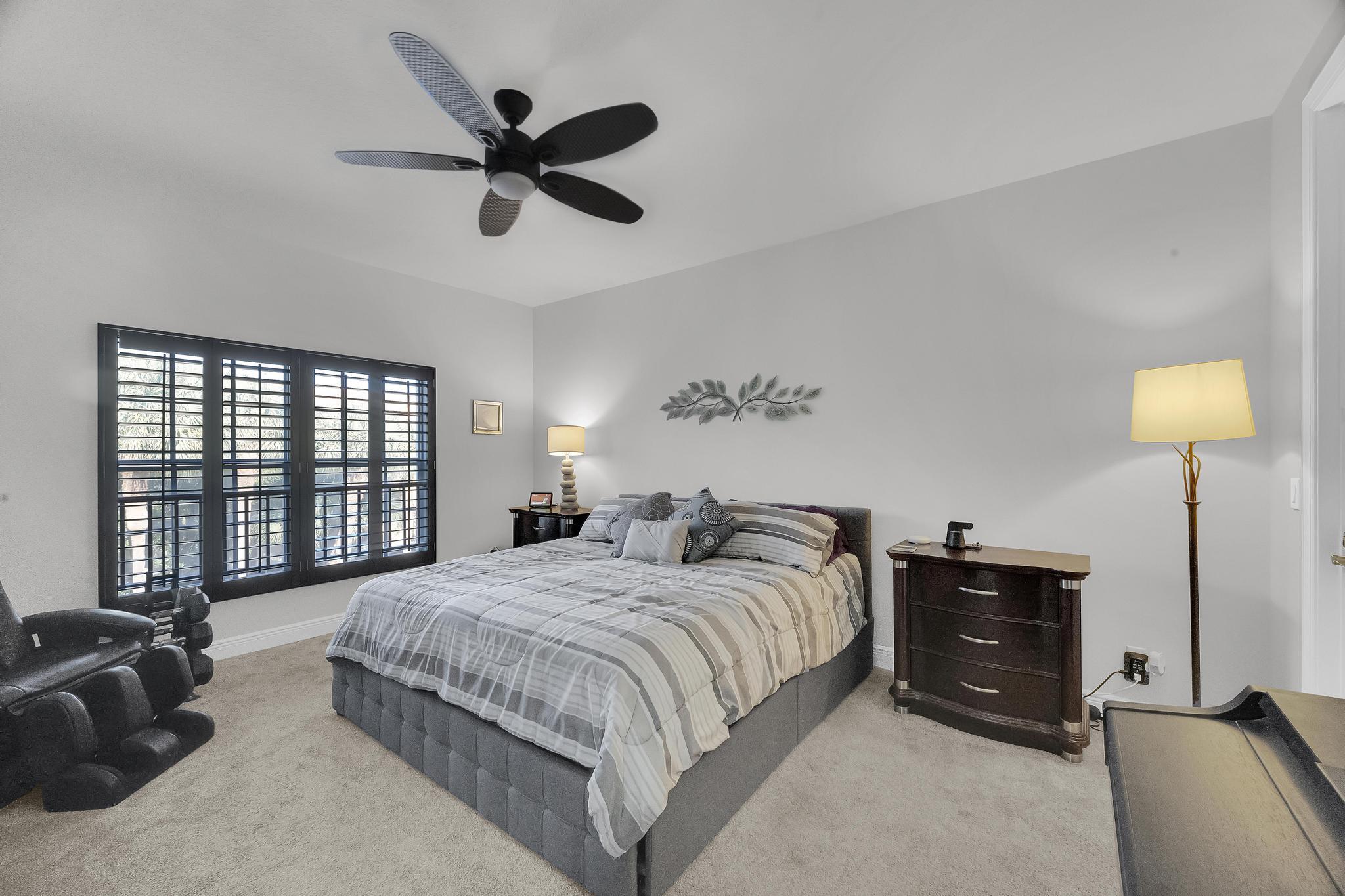 5600 Northeast Trieste Terrace Boca Raton, FL 33487 - Photo 25 of 44 a bedroom with a bed and a window