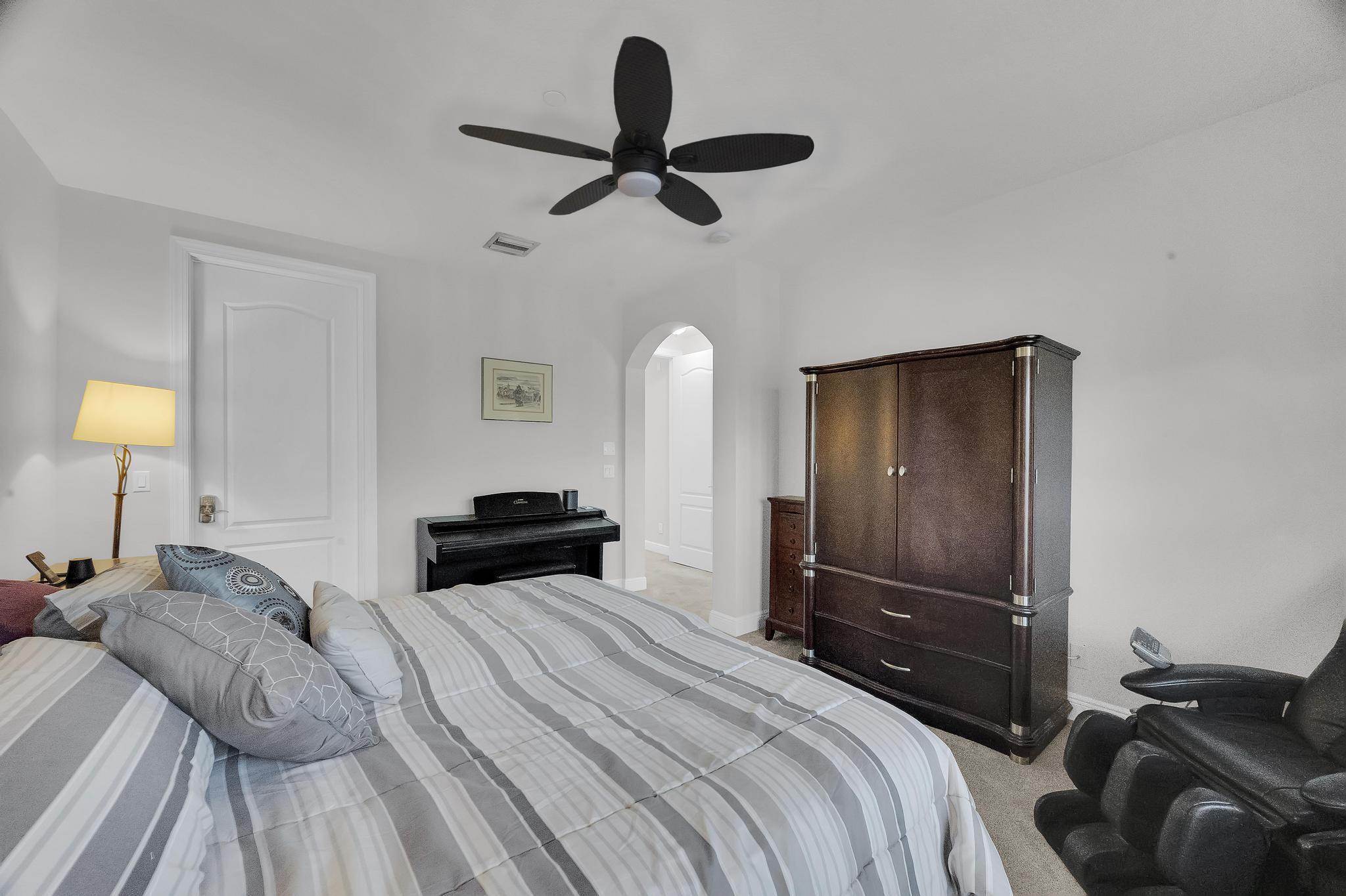 5600 Northeast Trieste Terrace Boca Raton, FL 33487 - Photo 26 of 44 a bedroom with a bed and a lamp