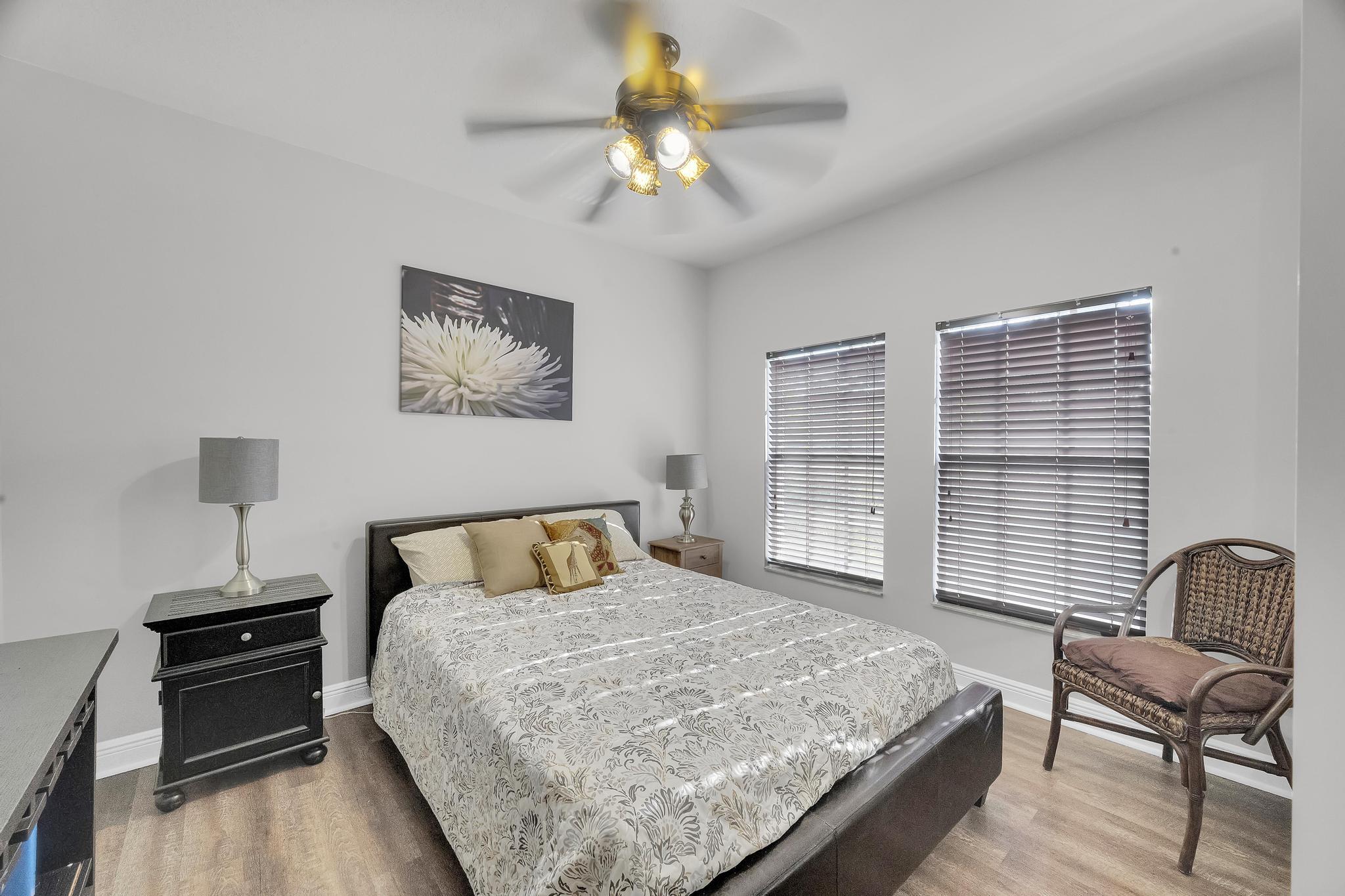 5600 Northeast Trieste Terrace Boca Raton, FL 33487 - Photo 32 of 44 a bedroom with a bed and a chandelier