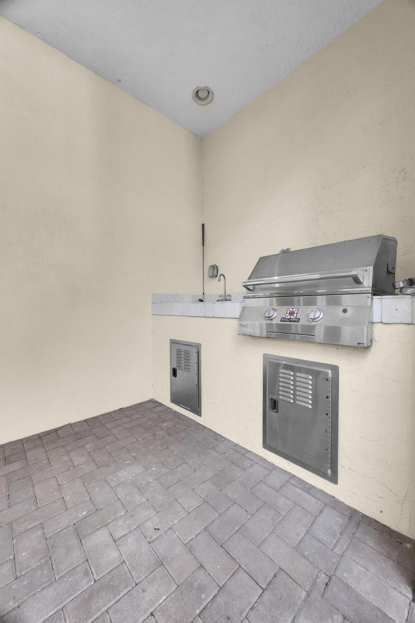 5600 Northeast Trieste Terrace Boca Raton, FL 33487 - Photo 38 of 44 a kitchen with a stove top oven and cabinets