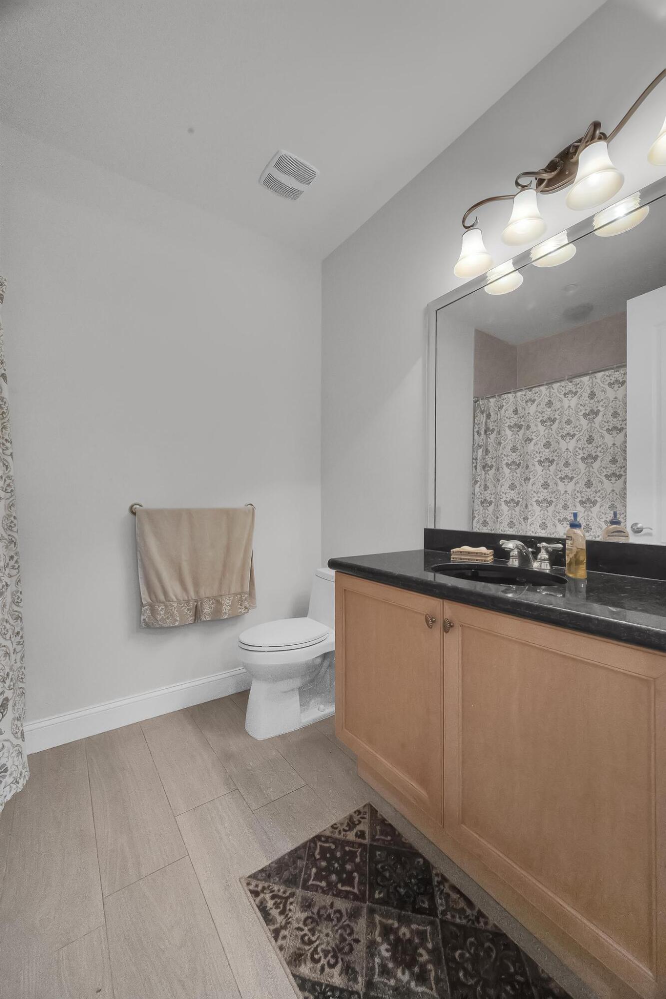 5600 Northeast Trieste Terrace Boca Raton, FL 33487 - Photo 7 of 44 a bathroom with a toilet a sink and mirror