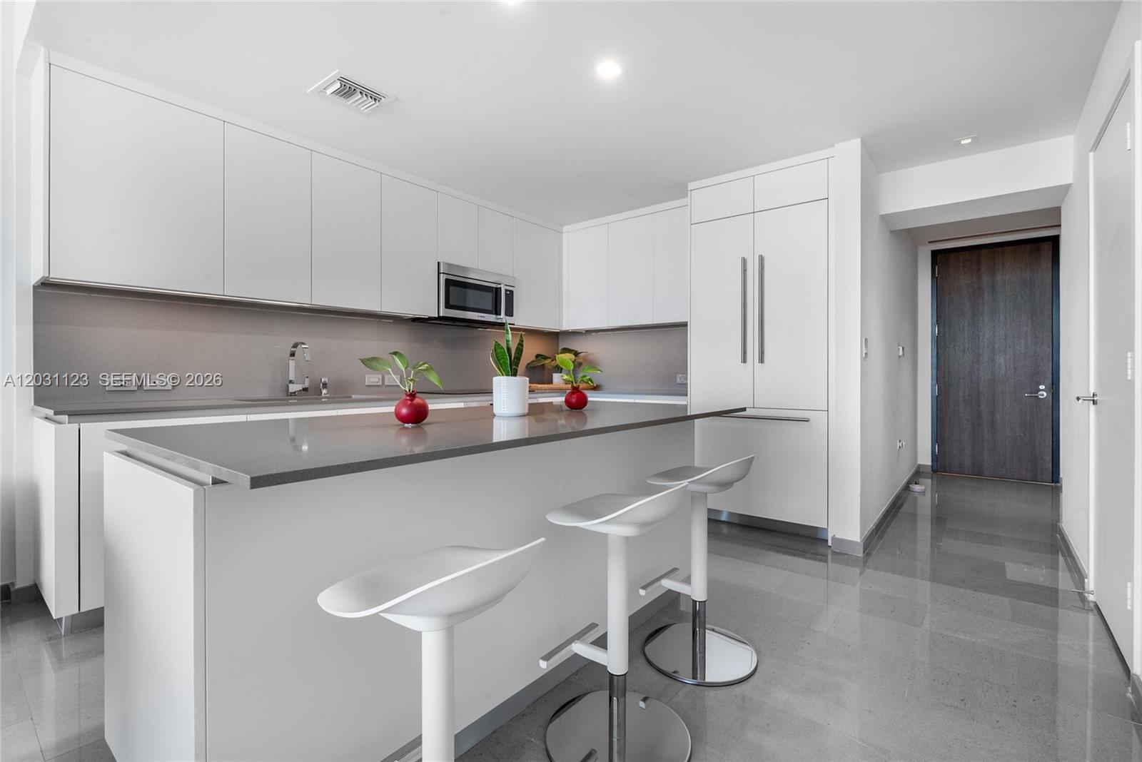 88 Southwest 7th Street, Unit 3208 Miami, FL 33130 - Photo 8 of 16 a kitchen with a sink cabinets and stainless steel appliances