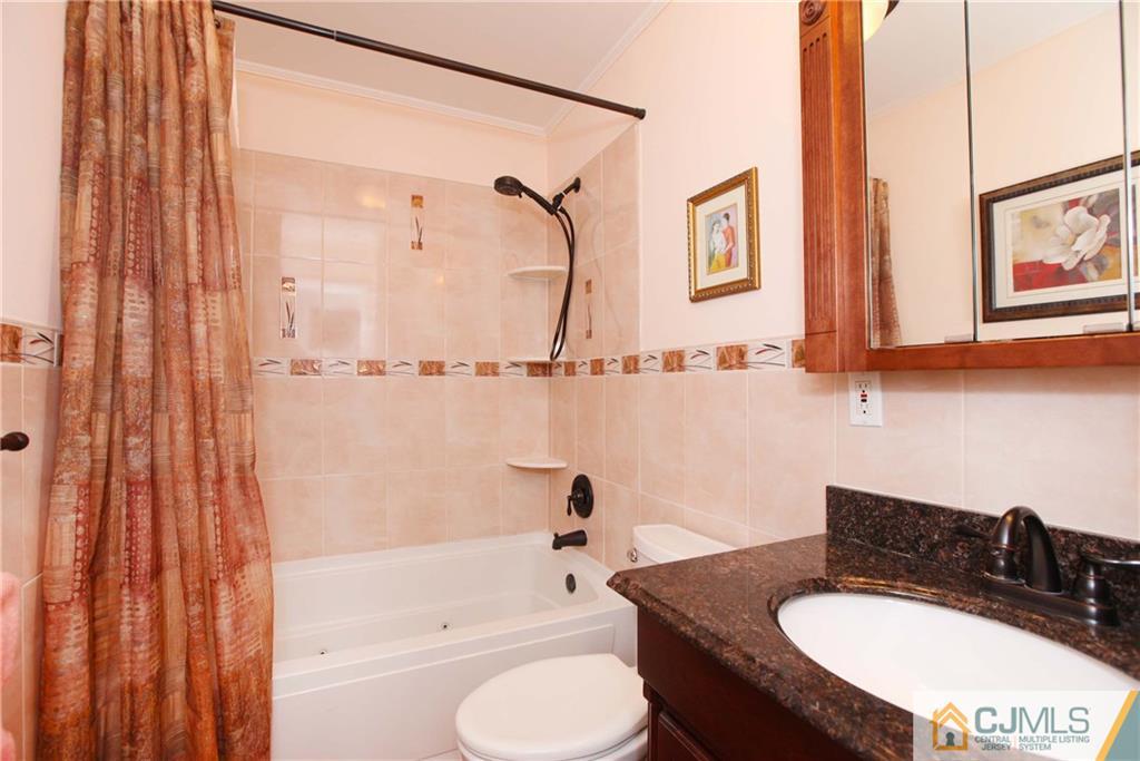 33 Glen Gary Road Middlesex, NJ 08846 - Photo 12 of 25 a bathroom with a granite countertop sink toilet a mirror and shower