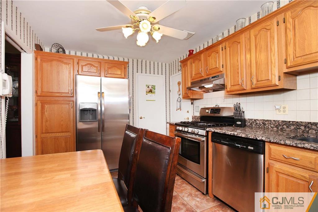 33 Glen Gary Road Middlesex, NJ 08846 - Photo 9 of 25 a kitchen with stainless steel appliances granite countertop a refrigerator a sink dishwasher a stove with wooden cabinets and floor