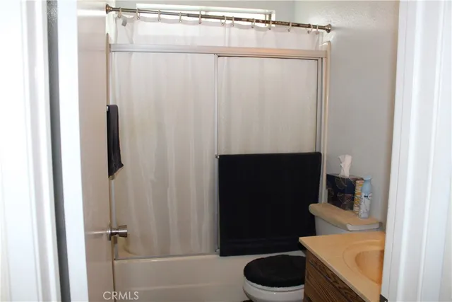 a bedroom with a bed and a flat tv screen on a dresser