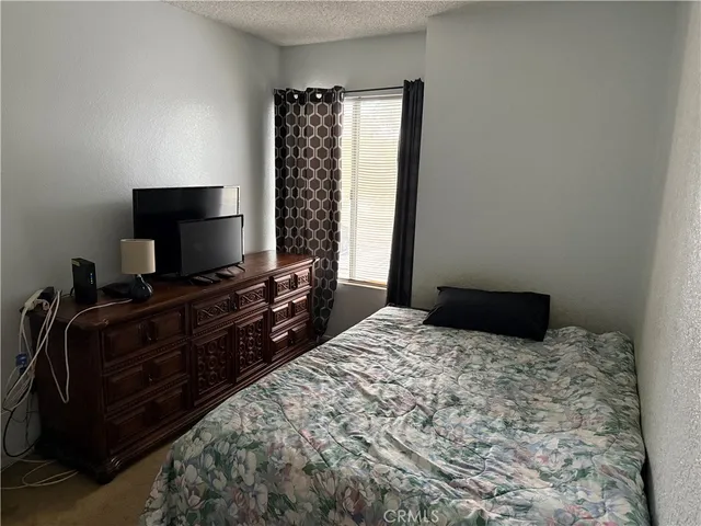 a bedroom with a bed and a flat tv screen on the table