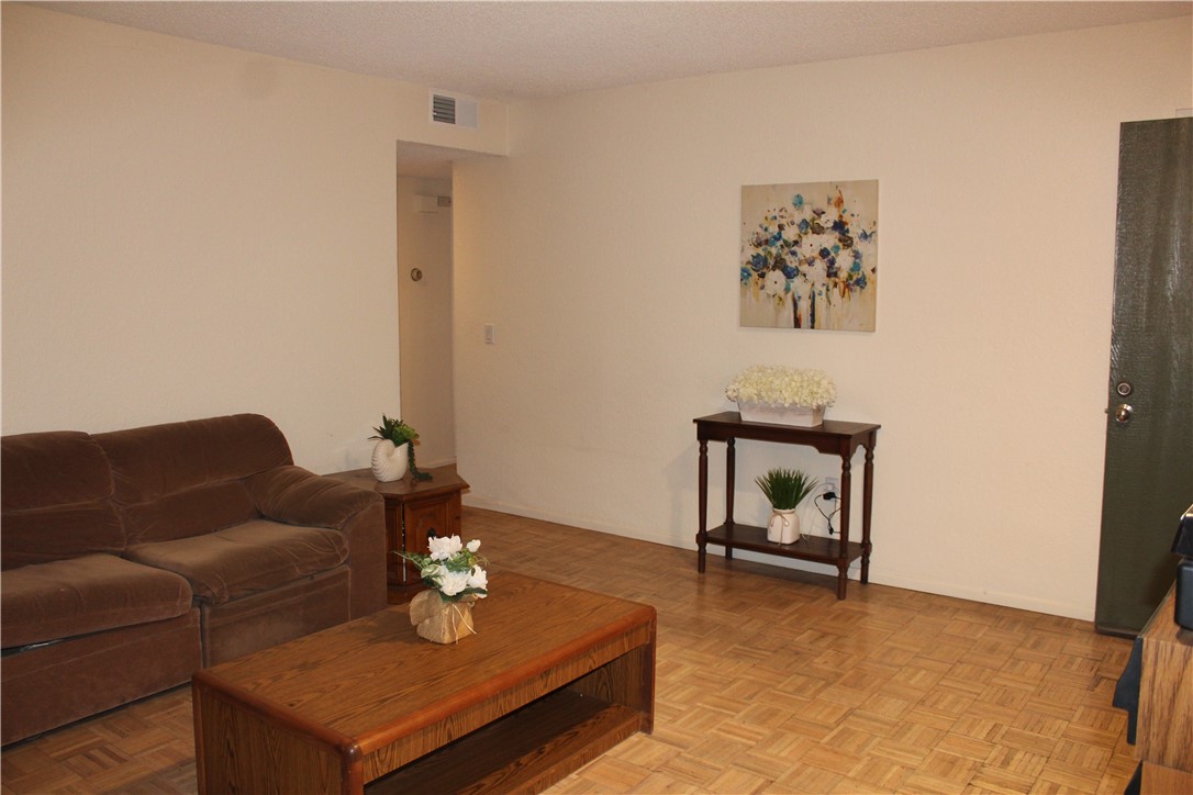 12141 Centralia Street, Unit 119 Lakewood, CA 90715 - Photo 4 of 31 a living room with furniture and a dining table