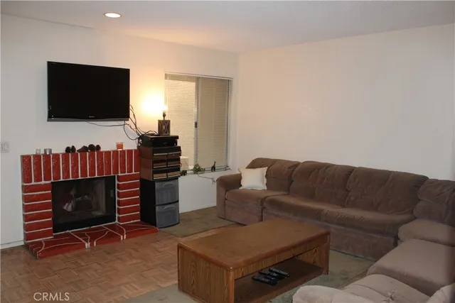 a living room with furniture a flat screen tv and a fireplace