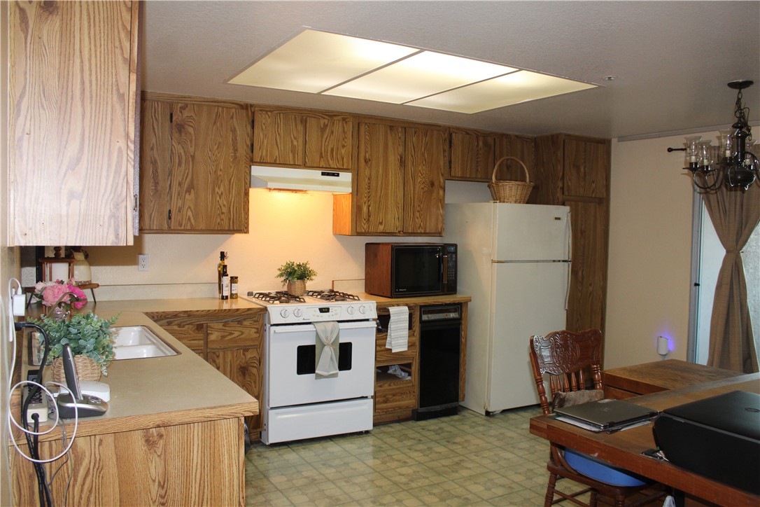 12141 Centralia Street, Unit 119 Lakewood, CA 90715 - Photo 7 of 31 a kitchen with a refrigerator and a stove top oven